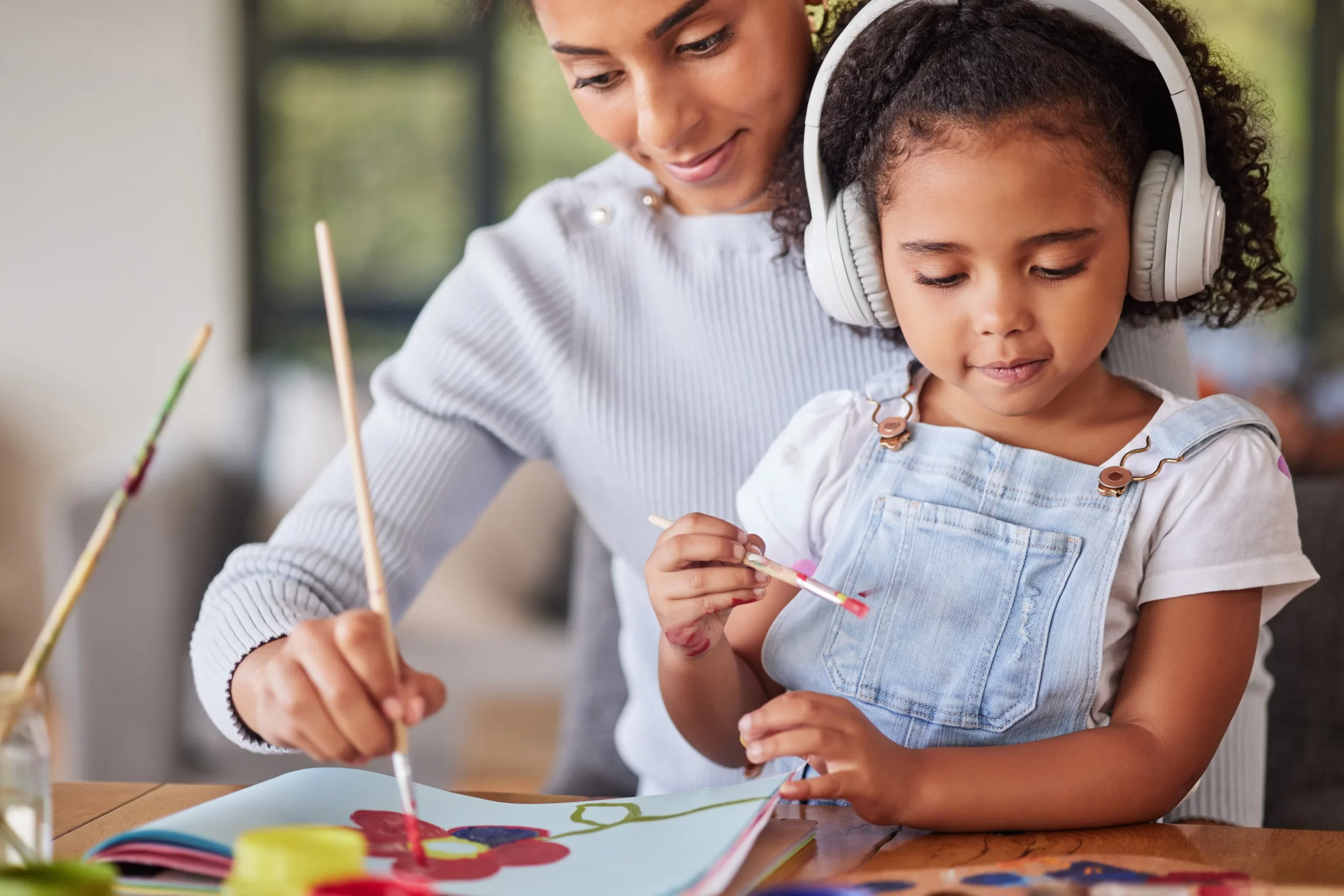 mother-girl-bonding-painting-activity-with-music-headphones-radio-audio-autism-help-brazilian-woman-art-parent-creative-child-listening-relax-autism-podcast-house-home